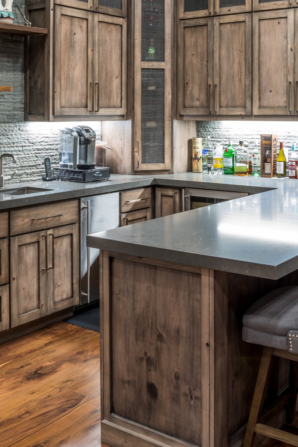 Basement Bar with Dark Wood Cabinets and Pendant Lighting