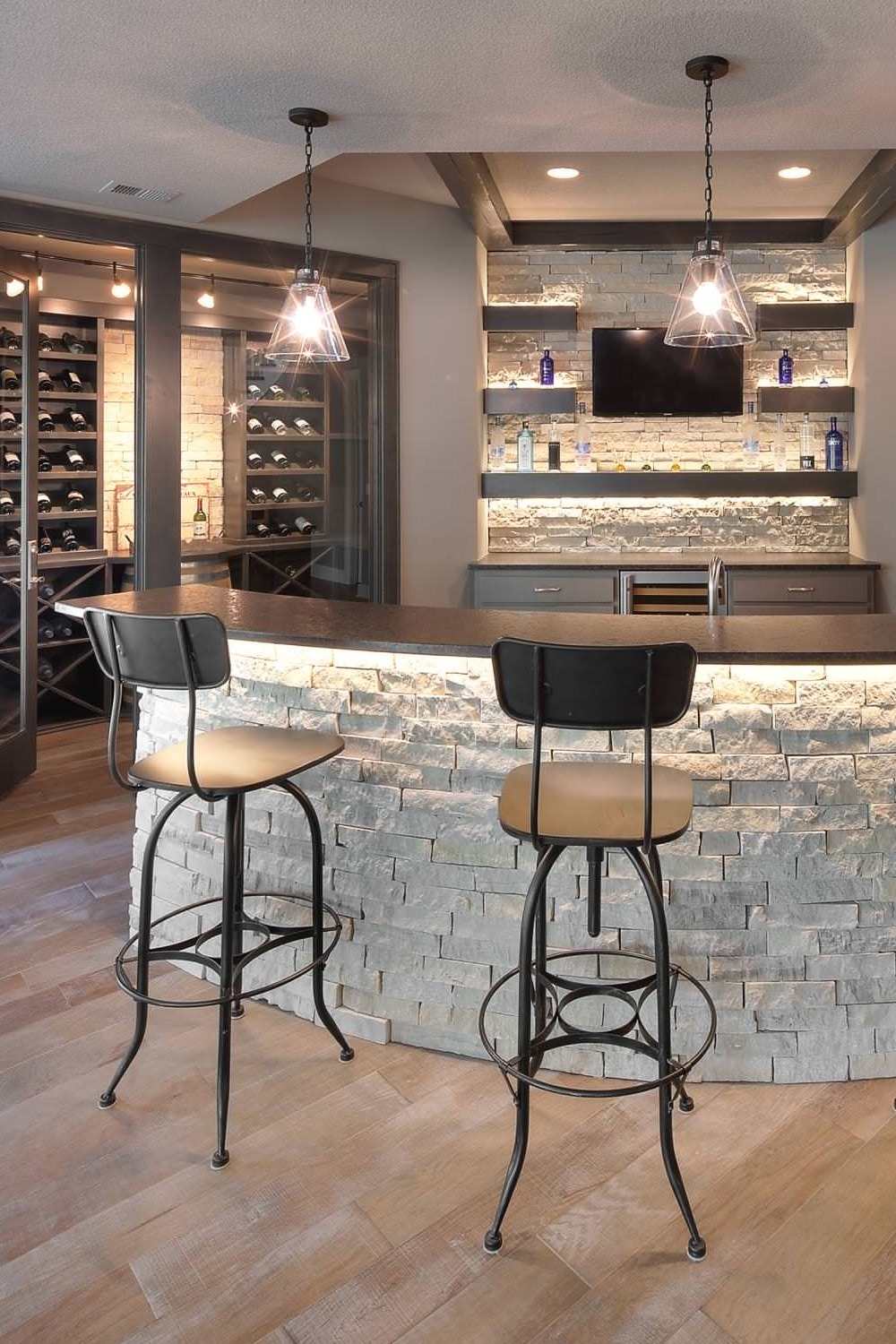 Classic Yet Modern Basement Bar with Shelving and Stone Countertops