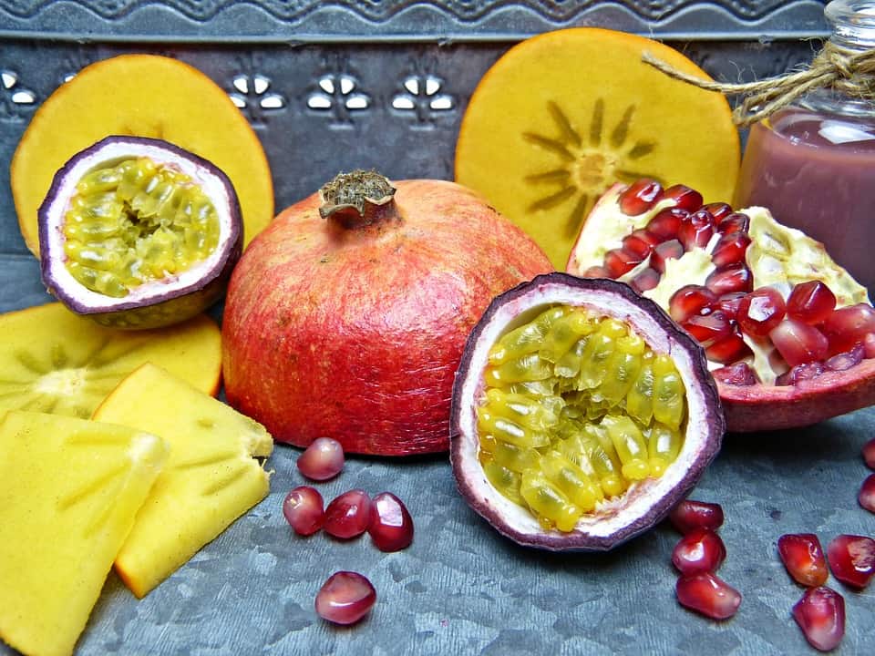 Halved passion fruit revealing golden pulp filled with black seeds against a wrinkled purple skin