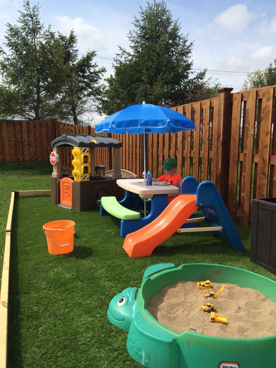 Playful Backyard with Mini House and Sandbox