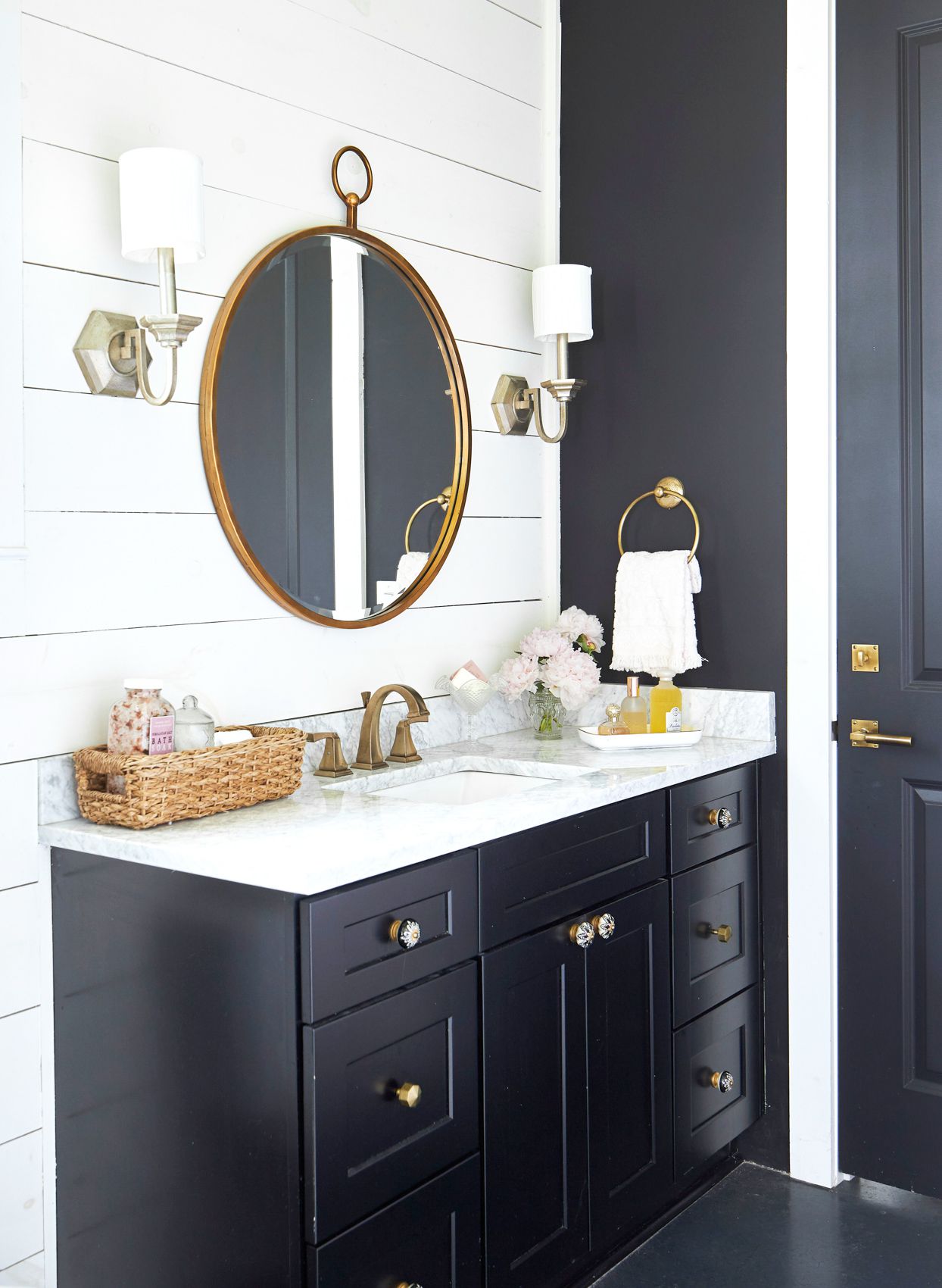 Black Corner Vanity with Round Mirror and White Shiplap Walls