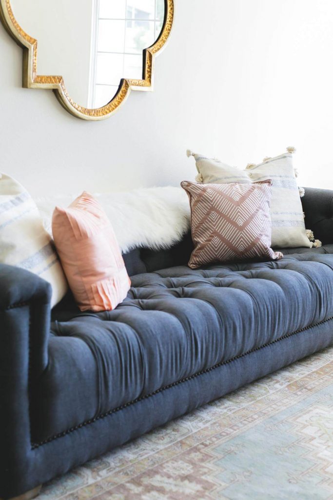 Modern Chic with Layered Mirrors Above a Sofa